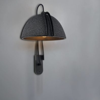 Steel-and-GFRC wall lamp with a volcanic-textured dome shade and warm interior